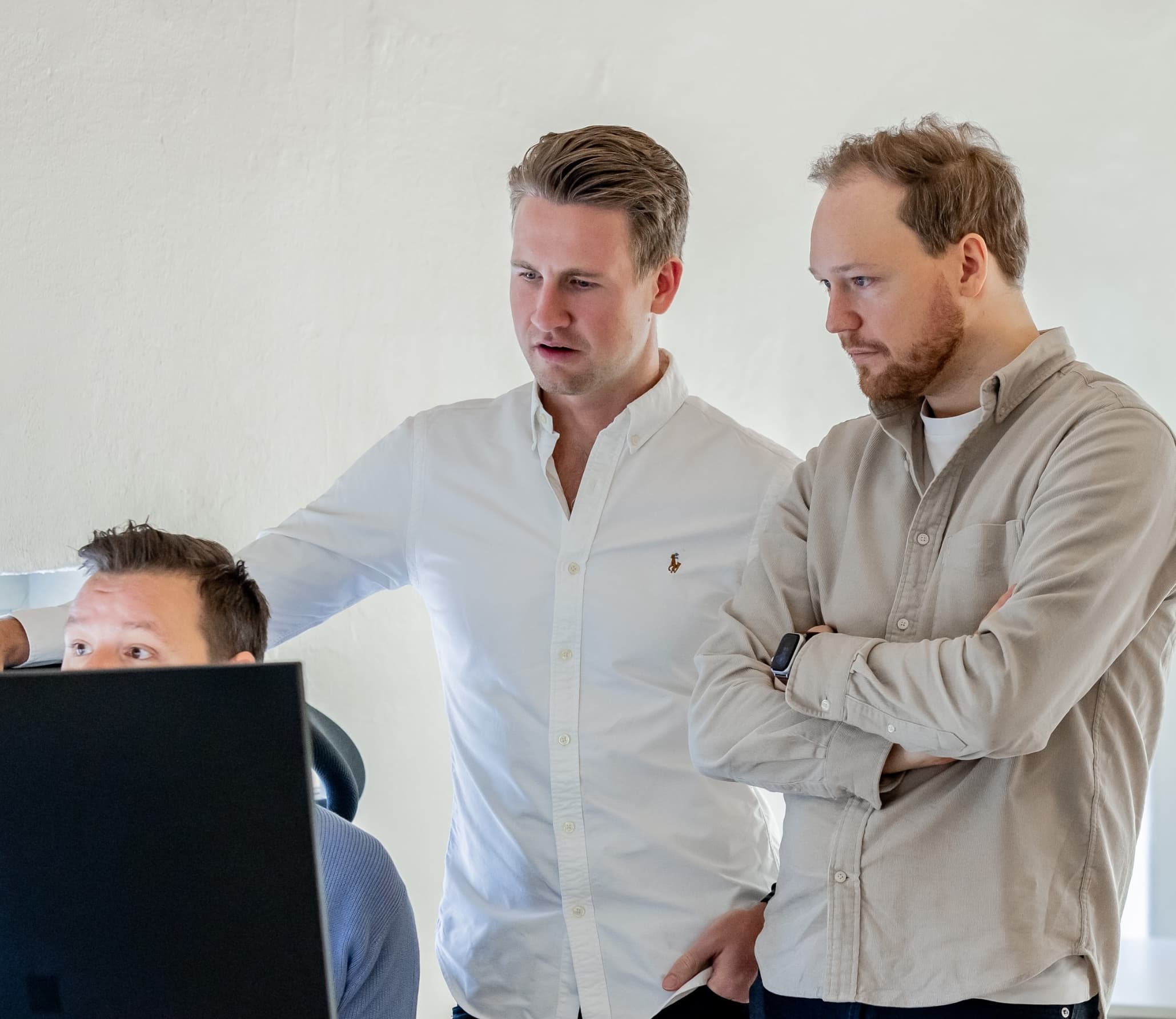 Tre ansatte ser på skjerm